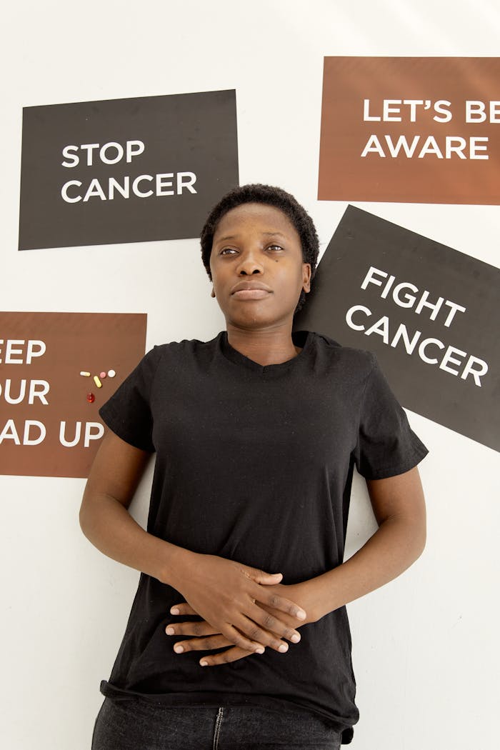 Portrait of a black woman supporting cancer awareness with motivational placards.